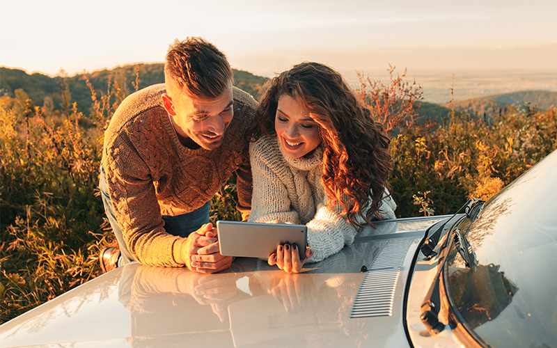 A boy and girl sitting in the car and wearing headphone