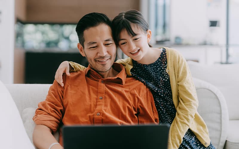 dad and daughter looking at laptop