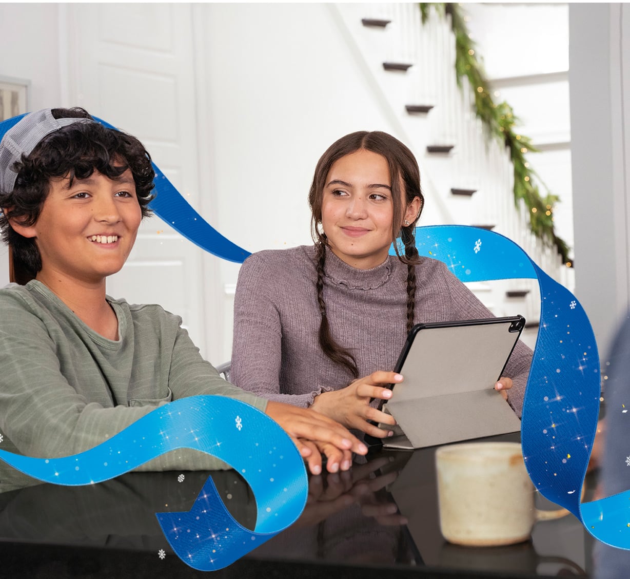 A boy and girl sitting and tablet in the table